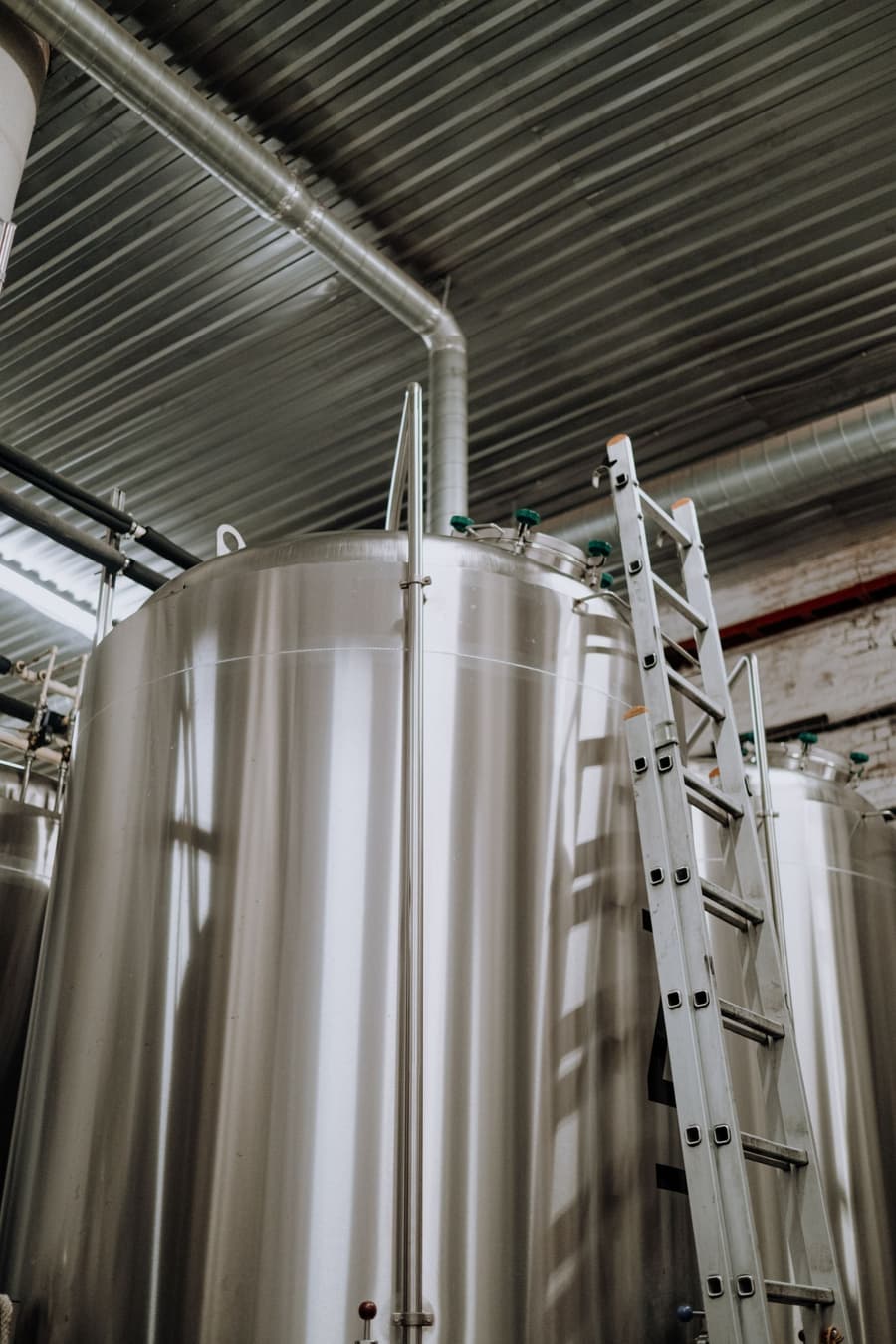 A steel ladder against a tall fermenter