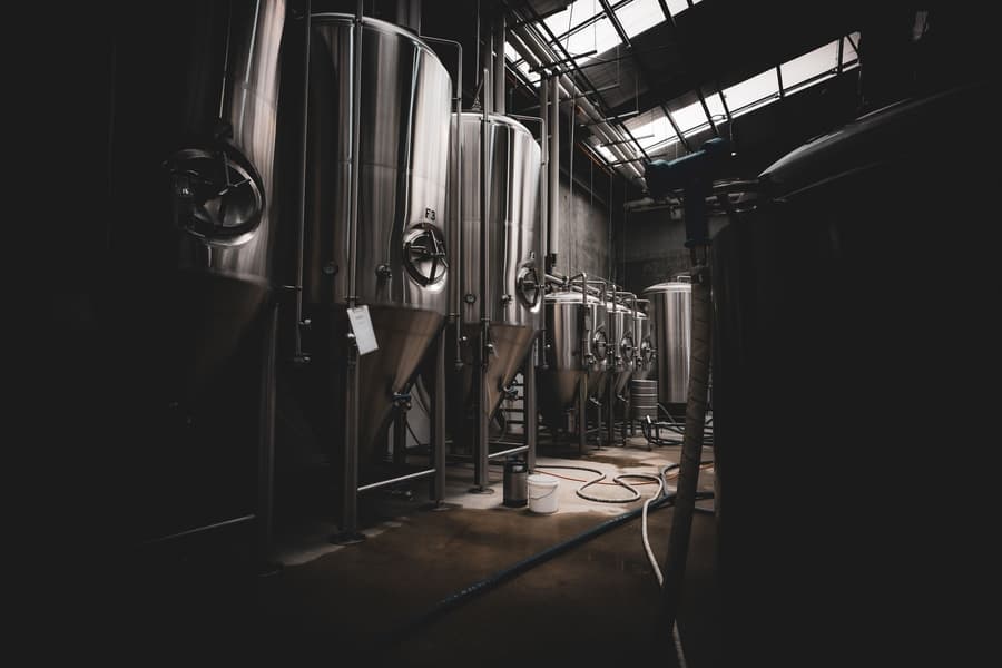Fermenters in a dark tank room under a skylight